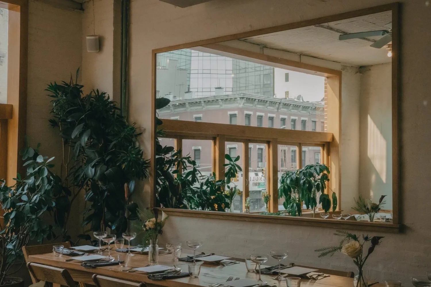 LEE’S Original Room set for dinner, with plants and a large wall mirror